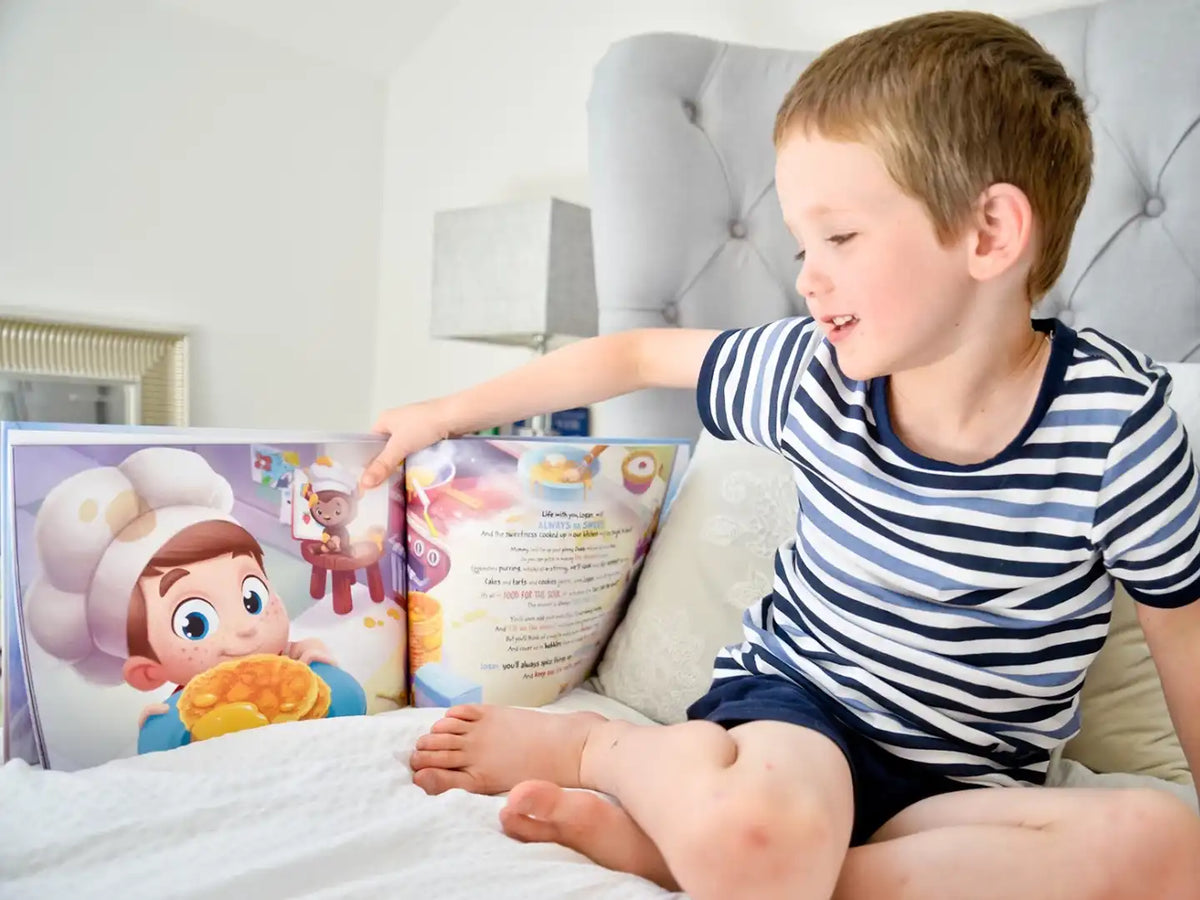 Un petit garçon en train de lire son cadeau personnalisé: un livre pour les familles.