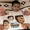 Un grand frère et ses petites soeurs avec leur livre personnalisé pour les enfants de chez Hourra Héros.