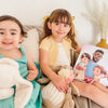 Deux petites filles avec le meilleur cadeau pour Papa : un livre personnalisé où ils sont les vedettes des histoires.