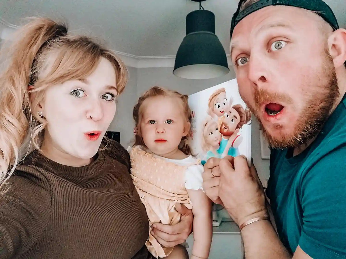 Un couple et leur petite fille tenant leur livre personnalisé pour les familles. Un cadeau idéal pour Papa et Maman.