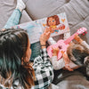 Une maman lisant avec sa petite fille un cadeau de fête des mères personnalisé.