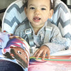 Une petite fille d'un an avec son livre d'anniversaire personnalisé.