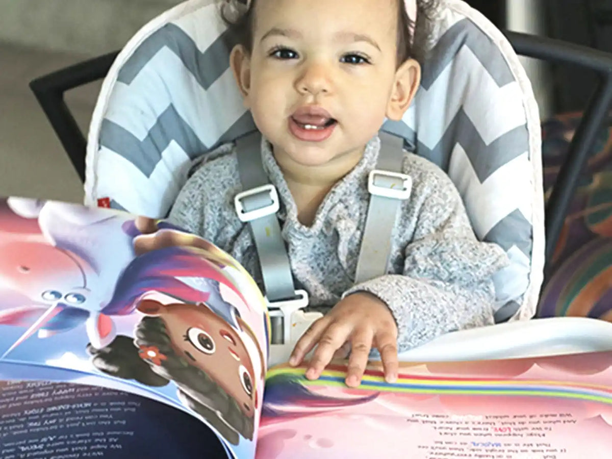 Une petite fille d'un an avec son livre d'anniversaire personnalisé.