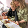 Une maman et sa fille lisent un livre d'anniversaire personnalisé.