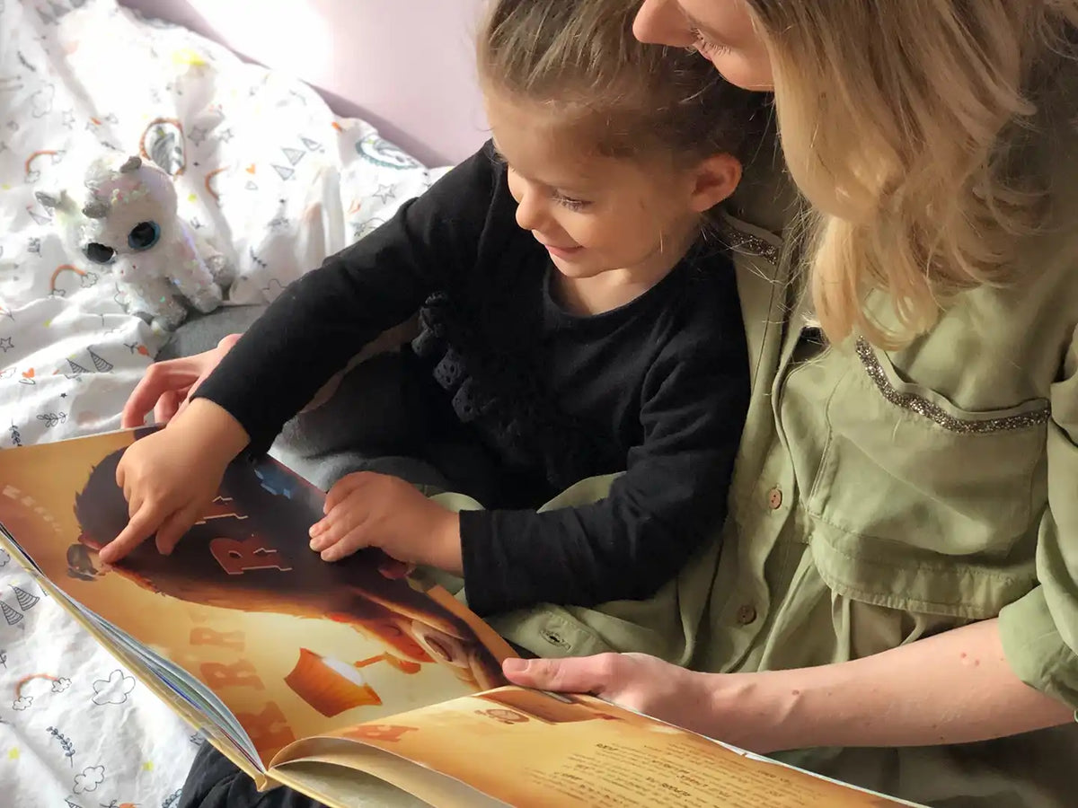 Une maman et sa fille lisent un livre d'anniversaire personnalisé.