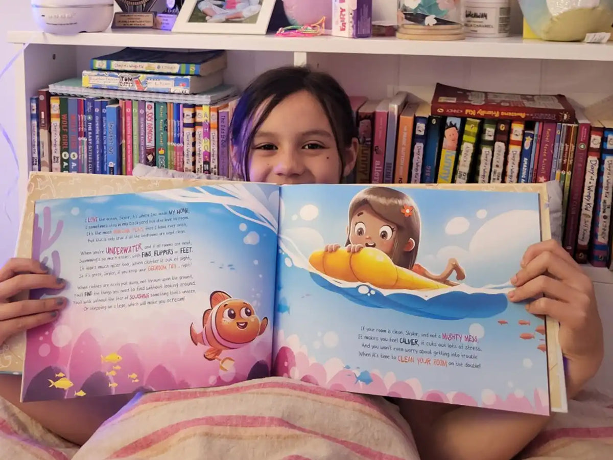 Une fille de sept ans tient son livre d'anniversaire personnalisé.