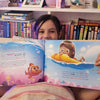 Une fille de huit ans tient son livre d'anniversaire personnalisé.