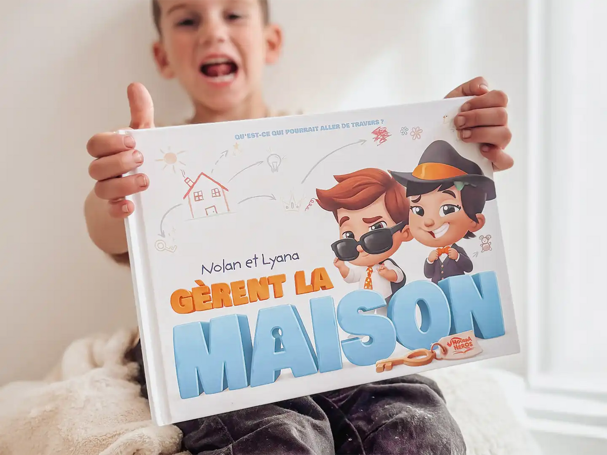 Un petit garçon tenant un livre personnalisé seul à la maison pour ses frères et sœurs.
