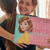 Une fille souriante avec son nouveau livre personnalisé qui était un cadeau de son amie.