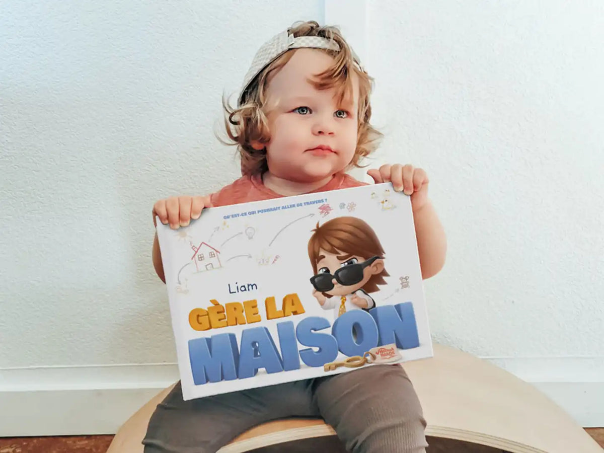 Liam tient son livre personnalisé Liam gère la maison et attend avec impatience des choses espiègles.