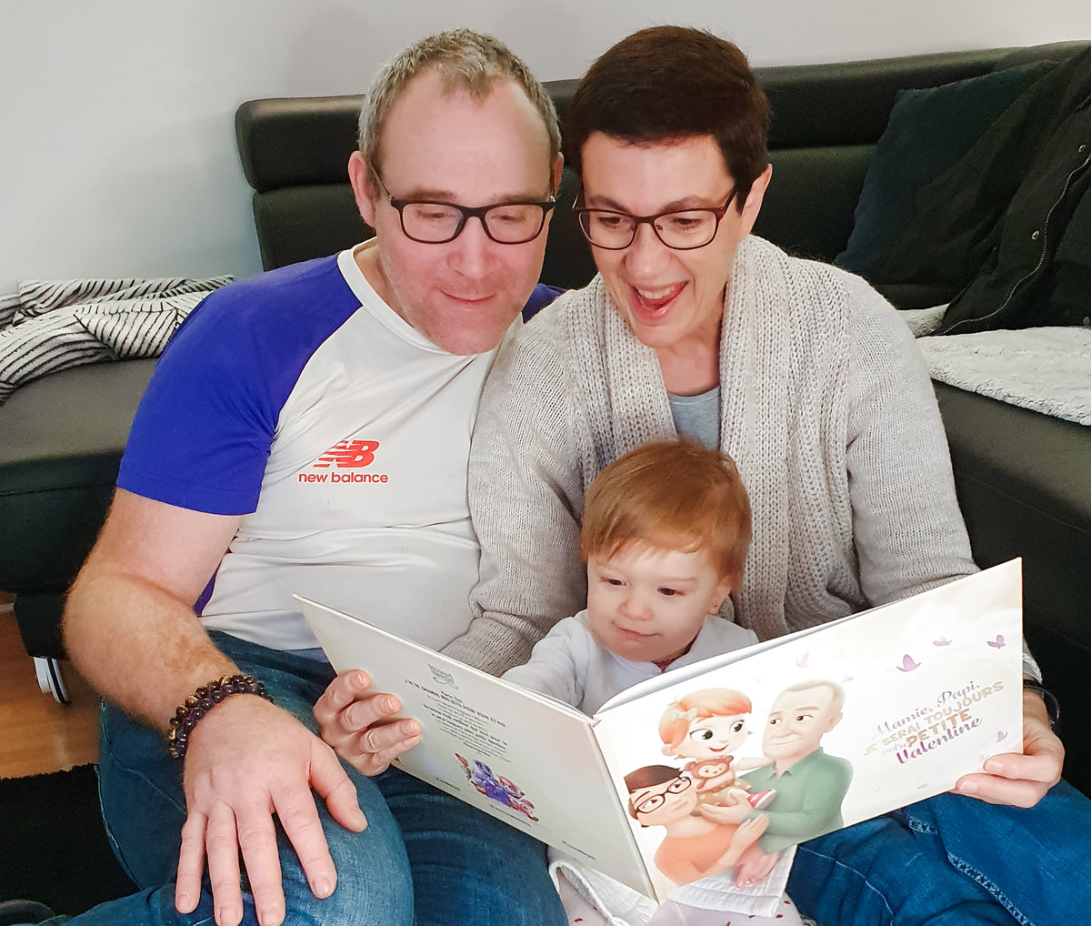Photo d'une Mamie et d'un Papy en train de lire un livre personnalisé pour grands parents.