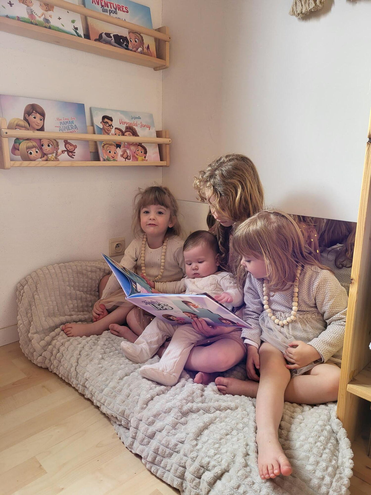 Une fratrie de quatre enfants avec le meilleur cadeau : un livre personnalisé.