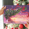Maman et bébé souriant avec le livre personnalisé “Notre Premier Noël 2025” de Martin & Maman, entourés de livres cadeaux.